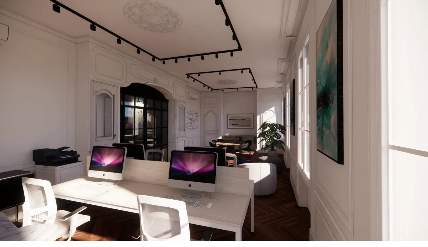 La grande salle de travail du plateau restauré : moulures et rosaces haussmanniennes, fenêtres en enfilade, verrière d'atelier